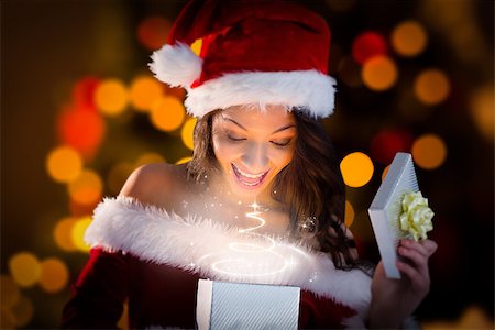 simsearch:693-06435898,k - Sexy santa girl opening gift against close up of christmas lights Stock Photo - Budget Royalty-Free & Subscription, Code: 400-07834475