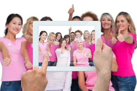 Composite image of hand holding tablet pc showing photograph of breast cancer activists Stock Photo - Budget Royalty-Free & Subscription, Code: 400-07834668