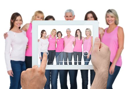 Composite image of hand holding tablet pc showing photograph of breast cancer activists Stock Photo - Budget Royalty-Free & Subscription, Code: 400-07834678