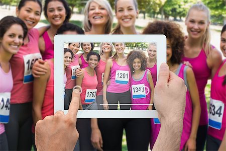 Composite image of hand holding tablet pc showing photograph of breast cancer activists Stock Photo - Budget Royalty-Free & Subscription, Code: 400-07834670