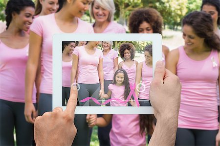 Composite image of hand holding device showing photograph of breast cancer activists Stock Photo - Budget Royalty-Free & Subscription, Code: 400-07834704