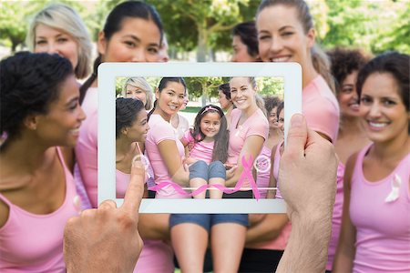 Composite image of hand holding device showing photograph of breast cancer activists Stock Photo - Budget Royalty-Free & Subscription, Code: 400-07834706