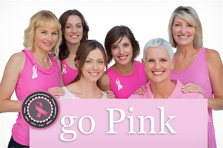 simsearch:400-07835111,k - Smiling women posing and wearing pink for breast cancer against pink card Stock Photo - Budget Royalty-Free & Subscription, Code: 400-07834861