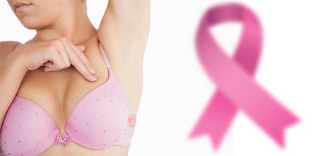 simsearch:400-07835111,k - Woman performing self breast examination against breast cancer awareness ribbon Stock Photo - Budget Royalty-Free & Subscription, Code: 400-07835105