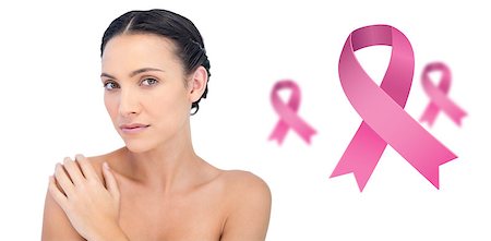 simsearch:400-07835111,k - Thoughtful young model posing looking at camera against pink breast cancer awareness ribbons Stock Photo - Budget Royalty-Free & Subscription, Code: 400-07835112