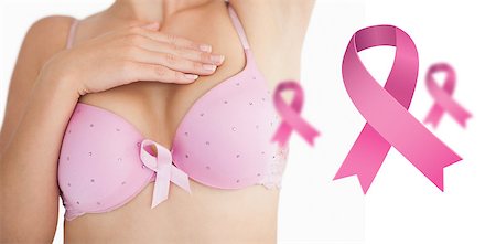 simsearch:400-07835111,k - Woman in bra with breast cancer awareness ribbon against pink breast cancer awareness ribbons Stock Photo - Budget Royalty-Free & Subscription, Code: 400-07835132