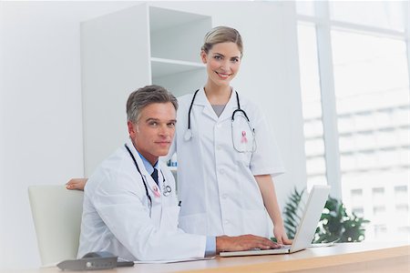 Medical team at the office wearing breast cancer awareness ribbon Stock Photo - Budget Royalty-Free & Subscription, Code: 400-07835165