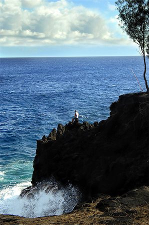 person sitting cliff edge - Local fisherman prepares for an evening of fishing by setting his poles out.  He is perched on the edge of a tremendous cliff in the McKinzie State Park on the windward side of the Big Island of Hawaii.  Against the forces of nature he is a tiny speck clinging to the rocky edge. Stock Photo - Budget Royalty-Free & Subscription, Code: 400-07839705