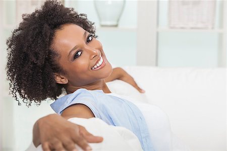 simsearch:400-06422339,k - A beautiful mixed race African American girl or young woman sitting on sofa at home looking happy and relaxed Foto de stock - Super Valor sin royalties y Suscripción, Código: 400-07894020