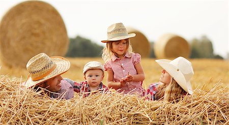 a young family on haystacks in cowboy hats Stock Photo - Budget Royalty-Free & Subscription, Code: 400-07894301