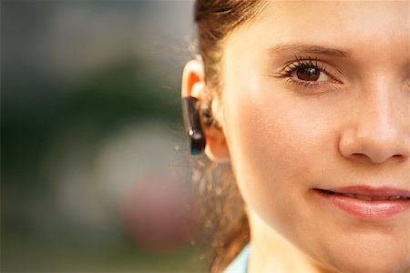 simsearch:400-07902993,k - Adult hispanic person with telephone wireless bluetooth device, looking at camera and smiling. Copy space Photographie de stock - Aubaine LD & Abonnement, Code: 400-07899764