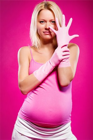 Pregnant attractive woman wearing rubber gloves posing over pink background Stock Photo - Budget Royalty-Free & Subscription, Code: 400-07892281