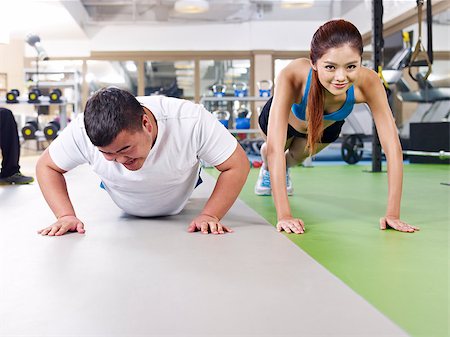 fat man exercising - an overweight young man doing push-ups together with a young lady. Stock Photo - Budget Royalty-Free & Subscription, Code: 400-07892675