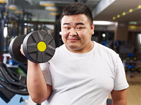 fat man exercising - an overweight young man holding a dumbbell in fitness center. Stock Photo - Budget Royalty-Free & Subscription, Code: 400-07892684