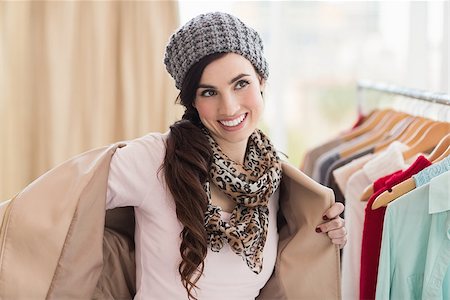 Pretty brunette taking off her jacket at clothes store Stock Photo - Budget Royalty-Free & Subscription, Code: 400-07901712