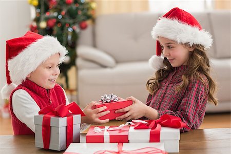 simsearch:640-03260410,k - Festive siblings smiling at their gifts at home in the living room Stock Photo - Budget Royalty-Free & Subscription, Code: 400-07902159