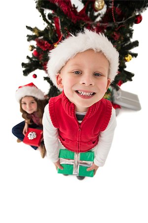 simsearch:640-03260410,k - Festive little siblings smiling at camera holding gifts on white background Stock Photo - Budget Royalty-Free & Subscription, Code: 400-07902161
