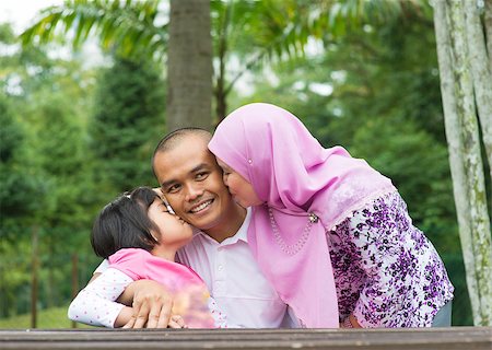 Happy Southeast Asian Muslim family, kissing on father face, outdoor lifestyle at nature green park. Foto de stock - Super Valor sin royalties y Suscripción, Código: 400-07915154