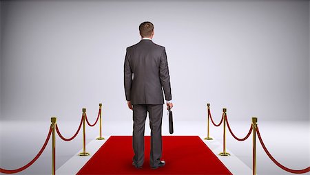 empty suitcase - Businessman in suit holding briefcase and standing on red carpet. Rear view. Business concept Stock Photo - Budget Royalty-Free & Subscription, Code: 400-07918932