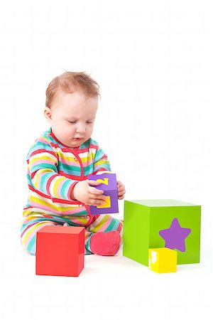 simsearch:400-06097126,k - Cute one year old baby girl in colorful clothing playing with colorful blocks isolated on white background. Creativity and development concept. Stock Photo - Budget Royalty-Free & Subscription, Code: 400-07919262