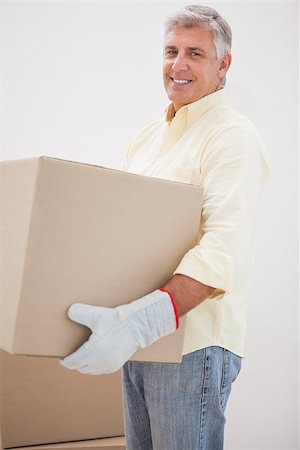 simsearch:400-07930718,k - Smiling man carrying cardboard moving boxes at home in the living room Stock Photo - Budget Royalty-Free & Subscription, Code: 400-07927839