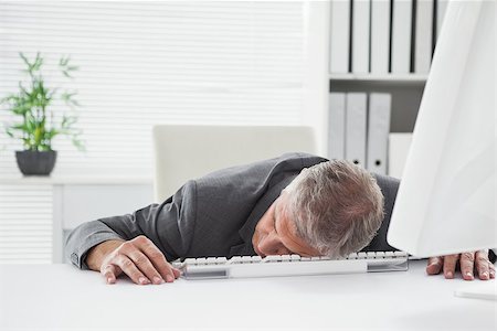 Exhausted businessman sleeping at his desk in his office Stock Photo - Budget Royalty-Free & Subscription, Code: 400-07927906