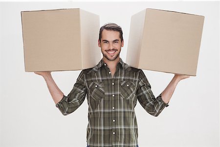simsearch:400-07930718,k - Happy man holding moving boxes at home in the living room Stock Photo - Budget Royalty-Free & Subscription, Code: 400-07928009