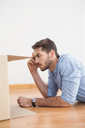 simsearch:400-07927836,k - Casual man looking inside cardboard box at home in the living room Stock Photo - Budget Royalty-Free & Subscription, Code: 400-07928012