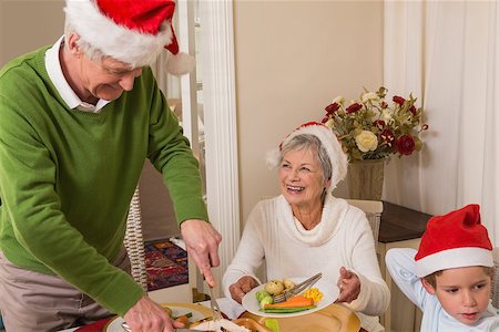 simsearch:640-03260410,k - Grandfather in santa hat serving roast turkey at christmas at home in the living room Stock Photo - Budget Royalty-Free & Subscription, Code: 400-07929075
