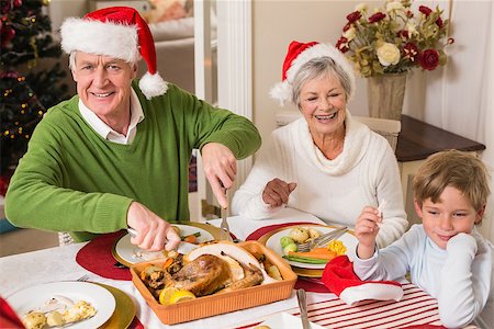 simsearch:640-03260410,k - Grandfather in santa hat carving roast turkey at christmas at home in the living room Stock Photo - Budget Royalty-Free & Subscription, Code: 400-07929072