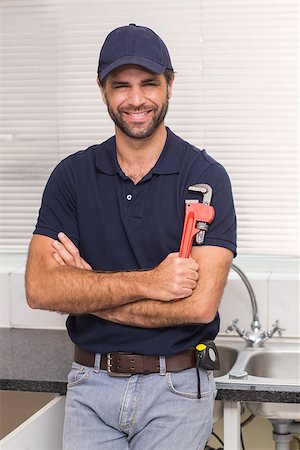 pipe wrench - Plumber smiling at the camera in the kitchen Stock Photo - Budget Royalty-Free & Subscription, Code: 400-07929399