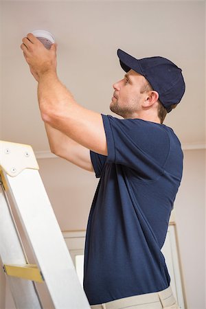 sensor - Focused handyman installing smoke detector with screwdriver on the ceiling Stock Photo - Budget Royalty-Free & Subscription, Code: 400-07929689