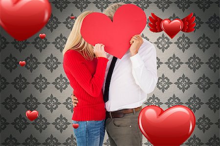 simsearch:400-07957420,k - Handsome man getting a heart card form wife against grey wallpaper Photographie de stock - Aubaine LD & Abonnement, Code: 400-07935053