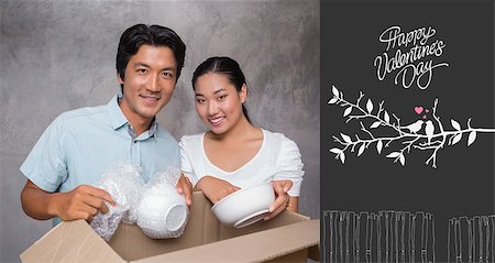 simsearch:400-07927836,k - Happy couple unpacking moving boxes against cute valentines message Stock Photo - Budget Royalty-Free & Subscription, Code: 400-07935683