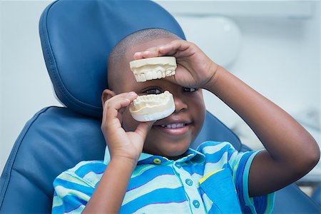 Portrait of smiling young boy holding mouth model in the dentists chair Stock Photo - Budget Royalty-Free & Subscription, Code: 400-07939063