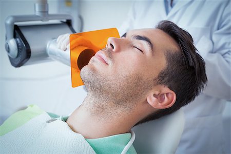 Close up of young man undergoing dental checkup in the dentists chair Stock Photo - Budget Royalty-Free & Subscription, Code: 400-07939203