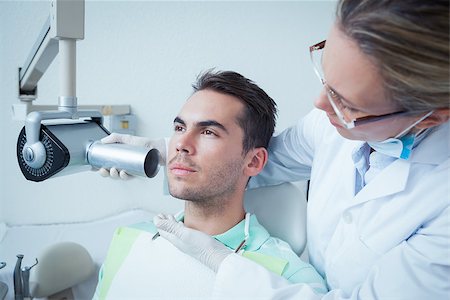 Serious young man undergoing dental checkup in the dentists chair Stock Photo - Budget Royalty-Free & Subscription, Code: 400-07939218