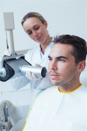 Serious young man undergoing dental checkup in the dentists chair Stock Photo - Budget Royalty-Free & Subscription, Code: 400-07939219