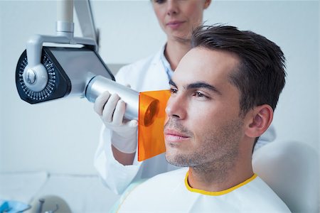 Serious young man undergoing dental checkup in the dentists chair Stock Photo - Budget Royalty-Free & Subscription, Code: 400-07939222