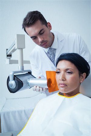 Serious young woman undergoing dental checkup in the dentists chair Photographie de stock - Aubaine LD & Abonnement, Code: 400-07939269