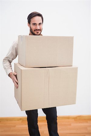 simsearch:400-07927836,k - Smiling man holding a cardboard moving box in the living room Stock Photo - Budget Royalty-Free & Subscription, Code: 400-07931543
