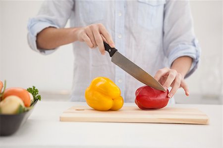 simsearch:6109-08390293,k - Pretty brunette slicing up peppers at home in the kitchen Stock Photo - Budget Royalty-Free & Subscription, Code: 400-07932019