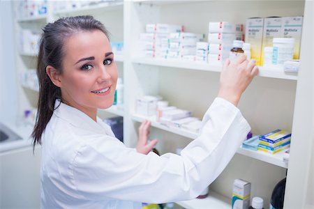 Smiling student taking jar from shelf in the pharmacy Stock Photo - Budget Royalty-Free & Subscription, Code: 400-07941528