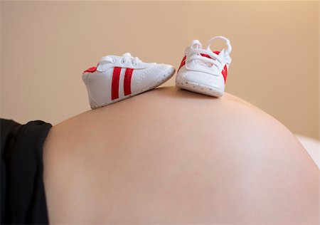 simsearch:400-04396054,k - Pregnant woman with a pair of baby sneakers on the belly Stock Photo - Budget Royalty-Free & Subscription, Code: 400-07955665