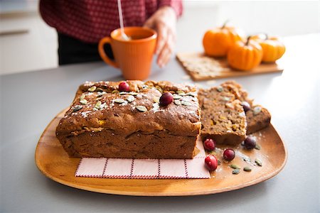 Closeup on freshly baked pumpkin bread with seeds and young housewife making tea in background Stock Photo - Budget Royalty-Free & Subscription, Code: 400-07956849