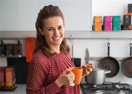 Portrait of happy young housewife drinking tea with freshly baked pumpkin bread with seeds Stock Photo - Budget Royalty-Free & Subscription, Code: 400-07956866