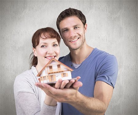 simsearch:400-07957420,k - Couple holding a model house against weathered surface Photographie de stock - Aubaine LD & Abonnement, Code: 400-07957320