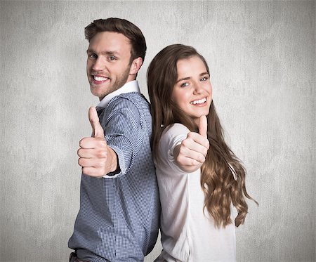 simsearch:400-07957355,k - Happy young couple gesturing thumbs up against weathered surface Stock Photo - Budget Royalty-Free & Subscription, Code: 400-07957349