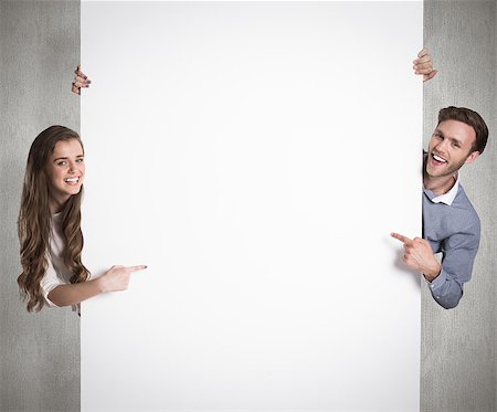 simsearch:400-07957355,k - Happy young couple with blank board against weathered surface Stock Photo - Budget Royalty-Free & Subscription, Code: 400-07957378