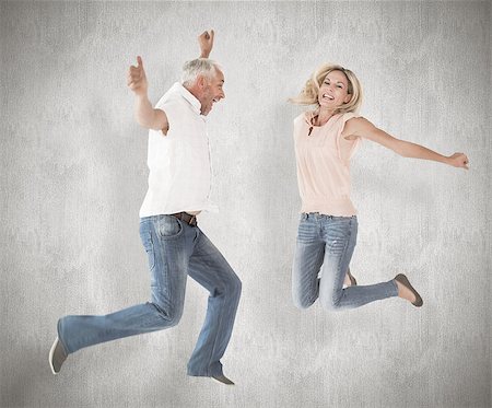 simsearch:400-07957355,k - Excited couple cheering and jumping against weathered surface Stock Photo - Budget Royalty-Free & Subscription, Code: 400-07957386